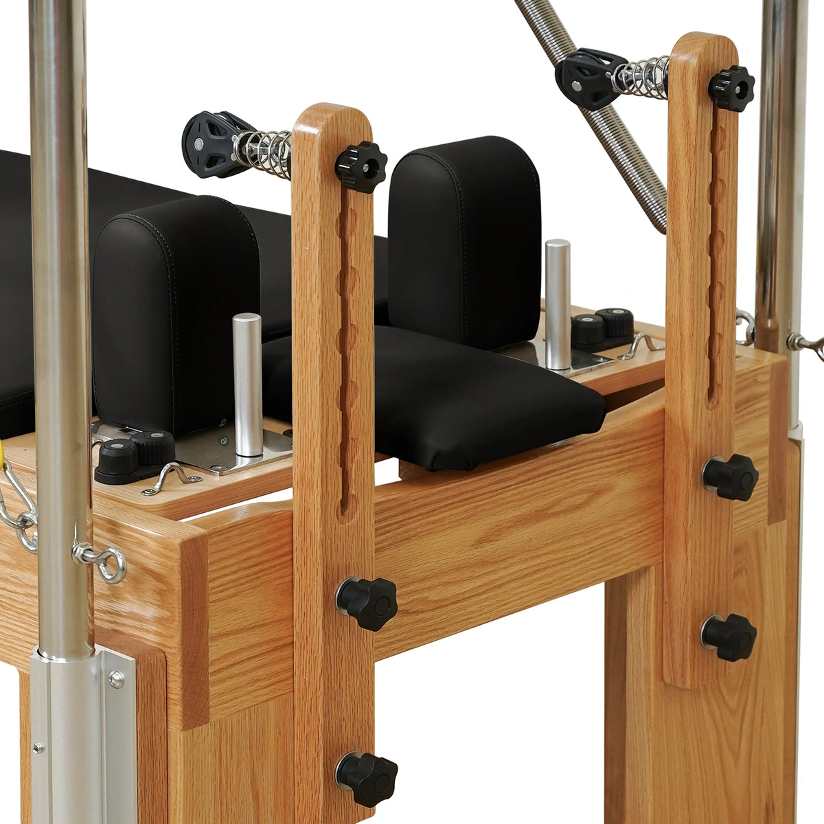 Adjustable wooden pulley risers and locking knobs on a Gymfrog Cadillac Reformer Combo