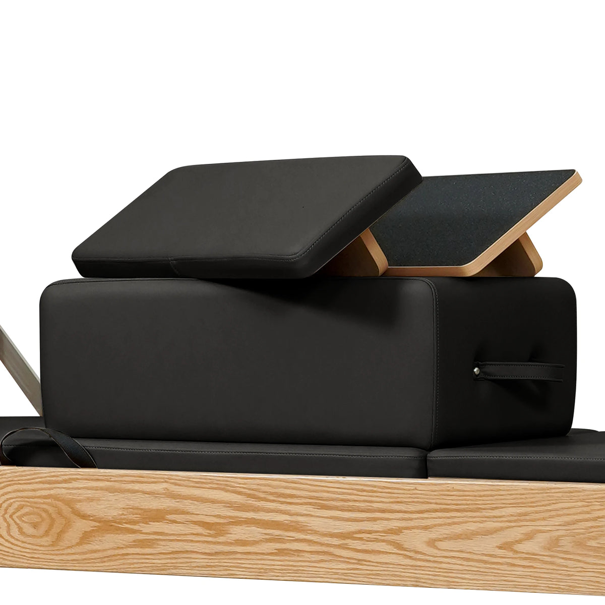 Stacked upholstered box and loose padded panels in black on a Gymfrog Cadillac Reformer Combo