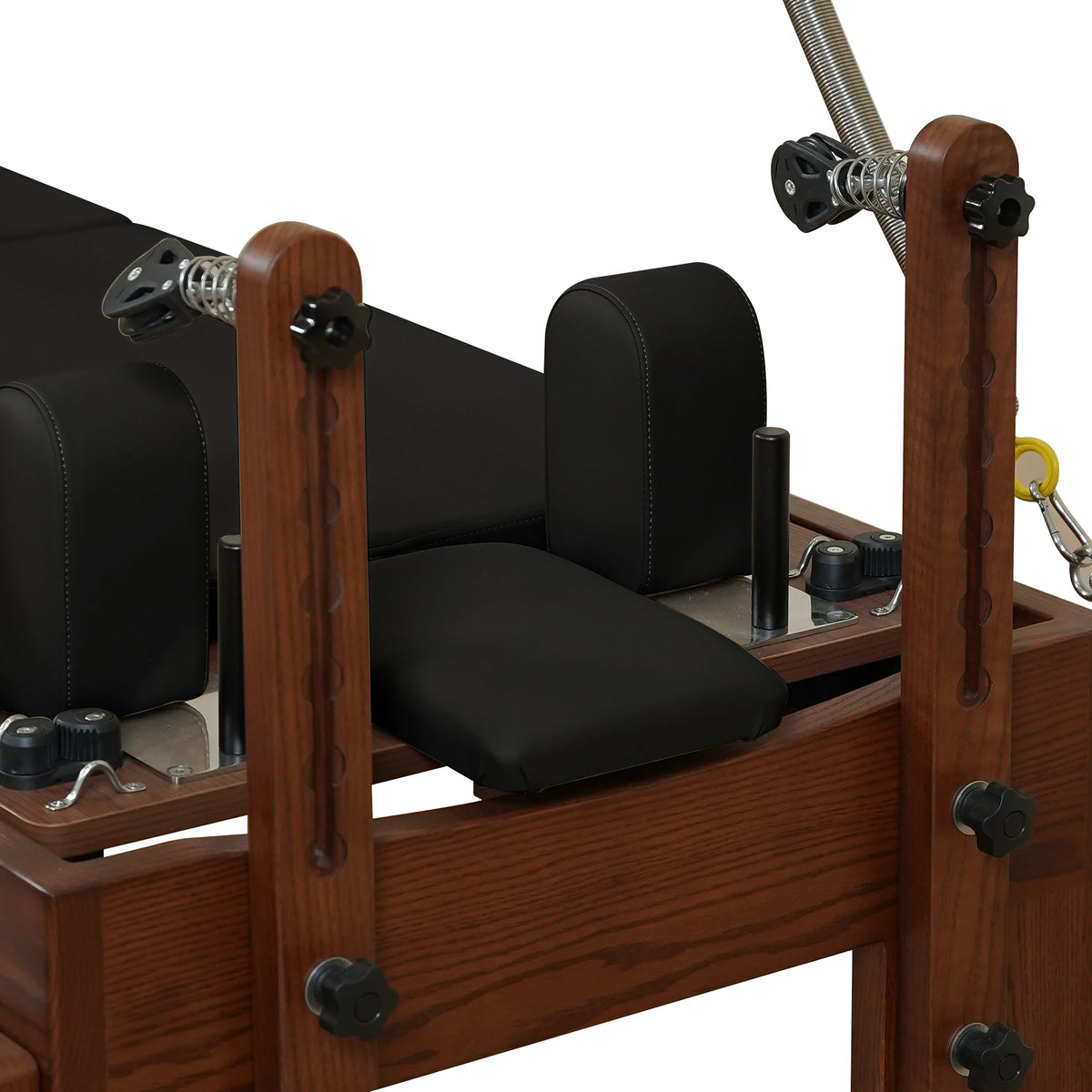 Adjustable wooden pulley risers and locking knobs on a Gymfrog Cadillac Reformer Combo
